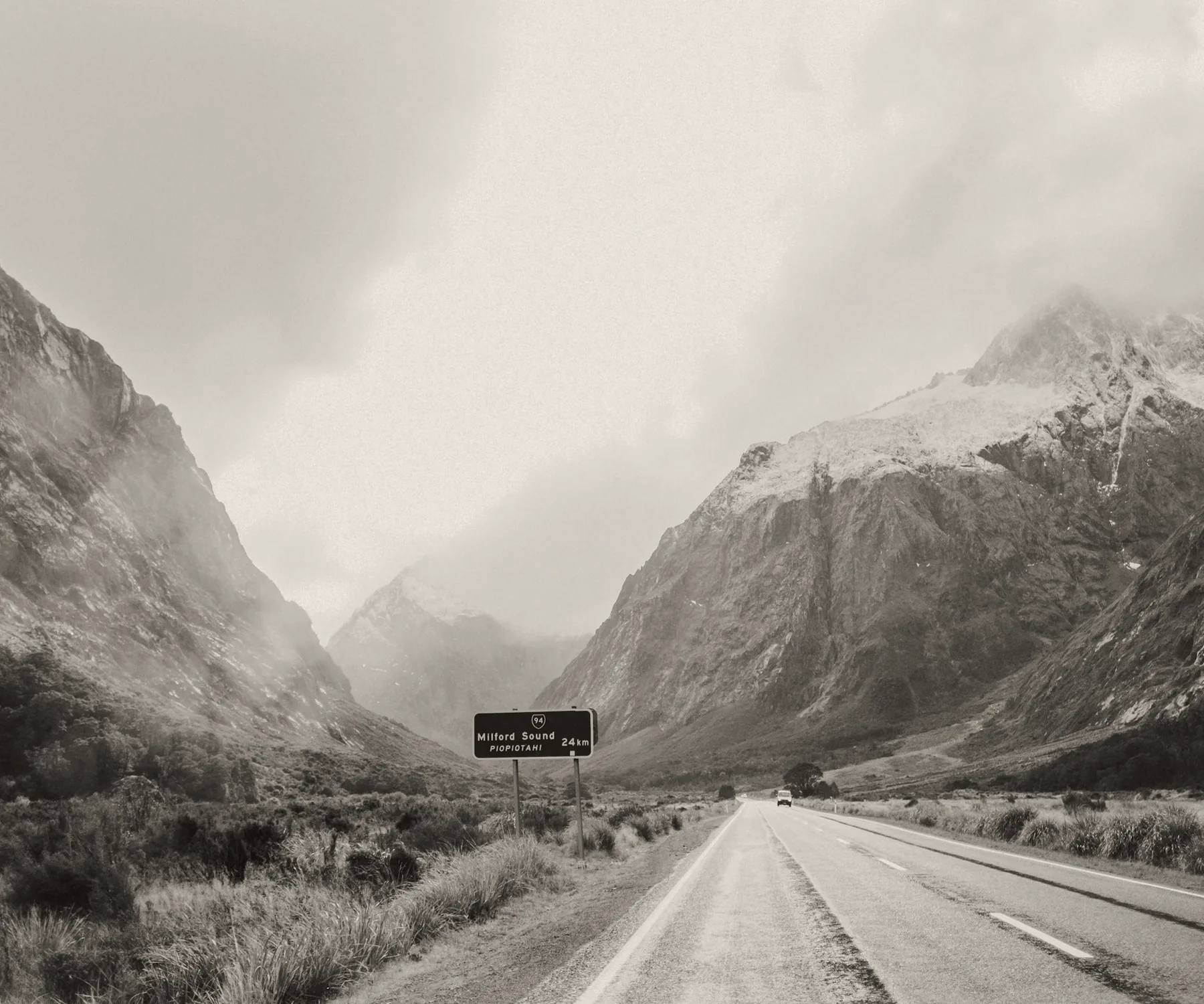 An empty road running between mountains toward Milford Sound